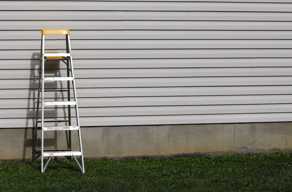 a step ladder against vinyl siding