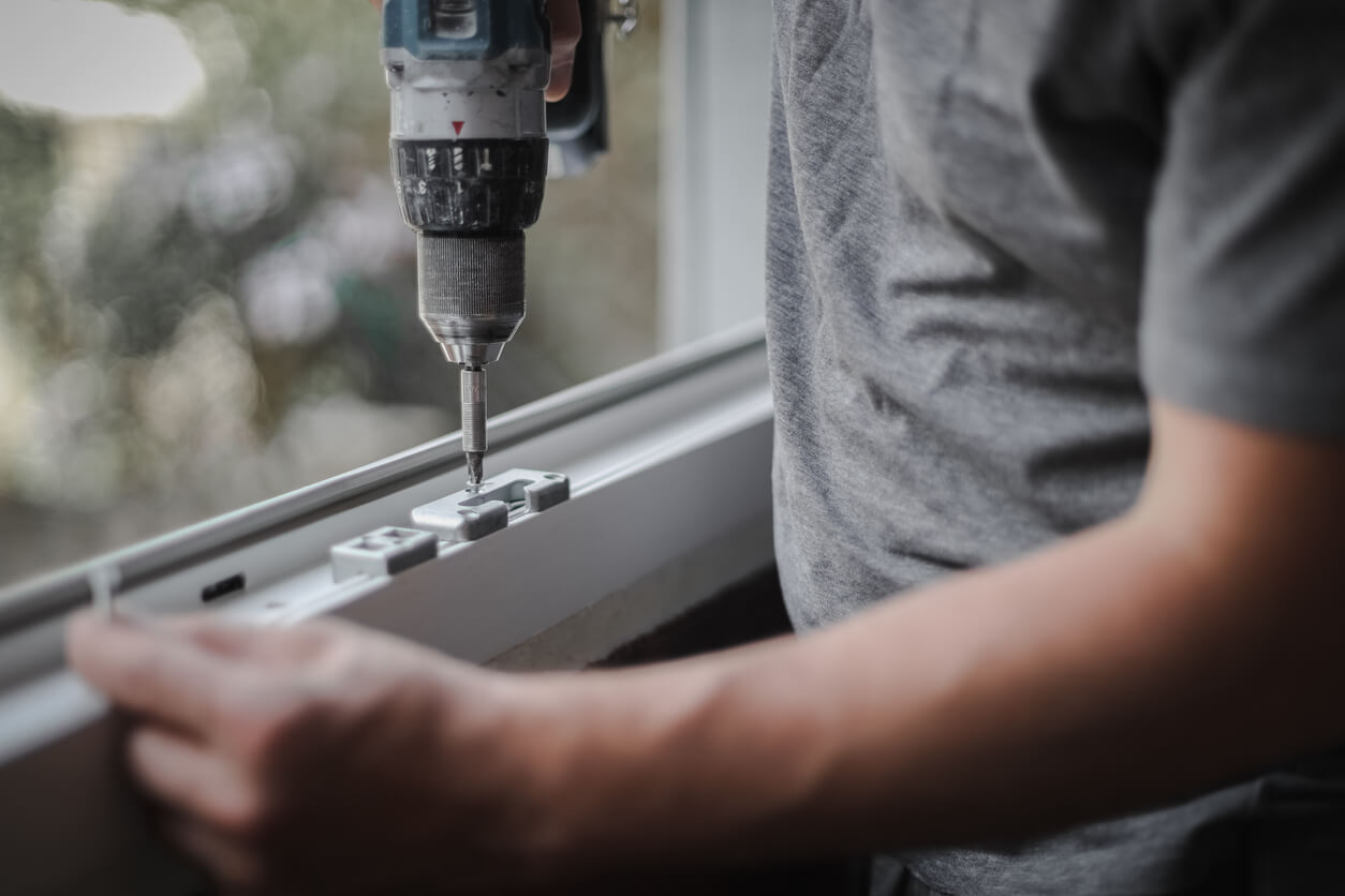 man installs fittings for a window frame